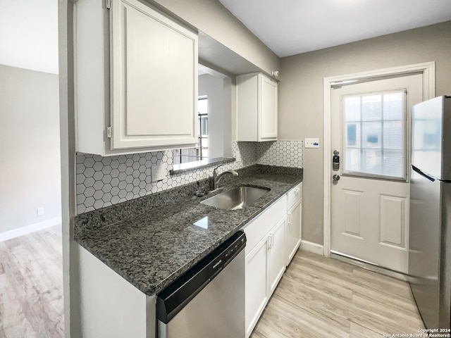 kitchen with light hardwood / wood-style flooring, stainless steel appliances, sink, and white cabinetry