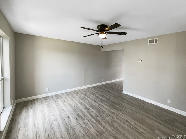 unfurnished room with ceiling fan and dark hardwood / wood-style flooring