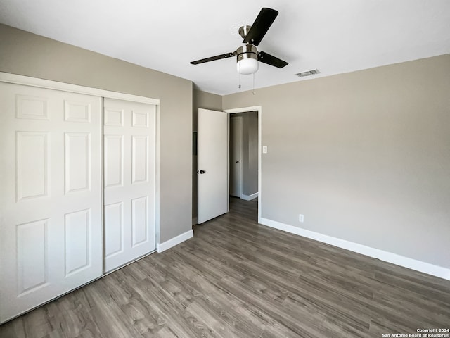 unfurnished bedroom with ceiling fan, a closet, and wood-type flooring