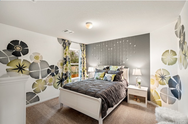 bedroom featuring a textured ceiling and carpet flooring