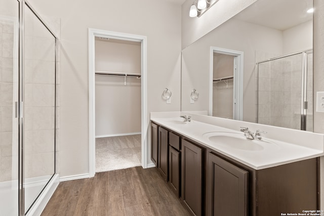 bathroom featuring hardwood / wood-style flooring, vanity, and walk in shower