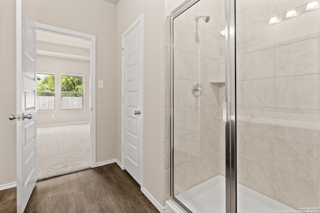 bathroom featuring wood-type flooring and a shower with shower door