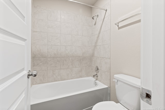 bathroom with tiled shower / bath combo and toilet