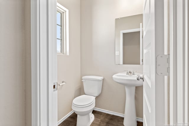 bathroom with hardwood / wood-style floors, toilet, and sink