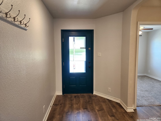 doorway to outside with a textured ceiling, dark hardwood / wood-style flooring, and ceiling fan