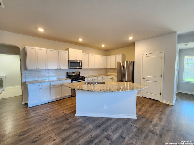 kitchen with an island with sink, appliances with stainless steel finishes, and white cabinetry