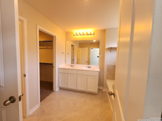 bathroom with tile patterned flooring, vanity, and a bathing tub