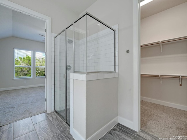 bathroom featuring hardwood / wood-style flooring, lofted ceiling, and an enclosed shower