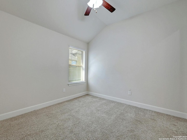 carpeted empty room featuring vaulted ceiling and ceiling fan