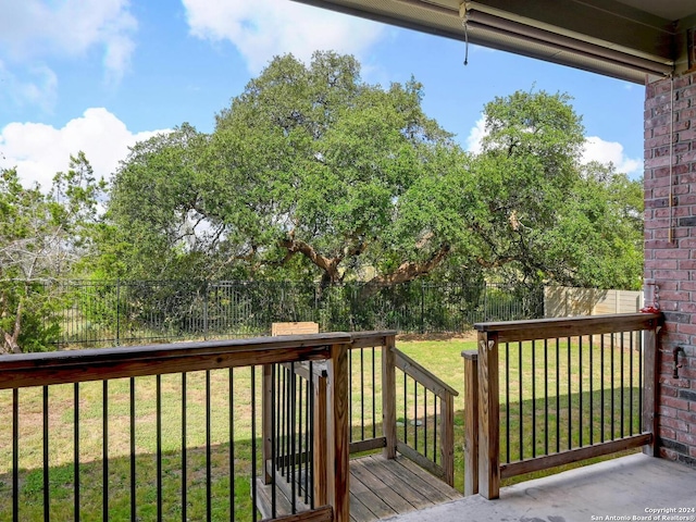 wooden deck featuring a lawn