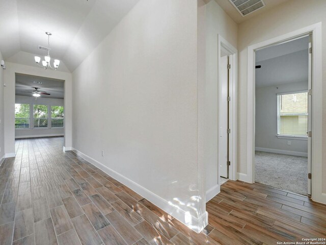 hall featuring lofted ceiling, hardwood / wood-style flooring, and plenty of natural light