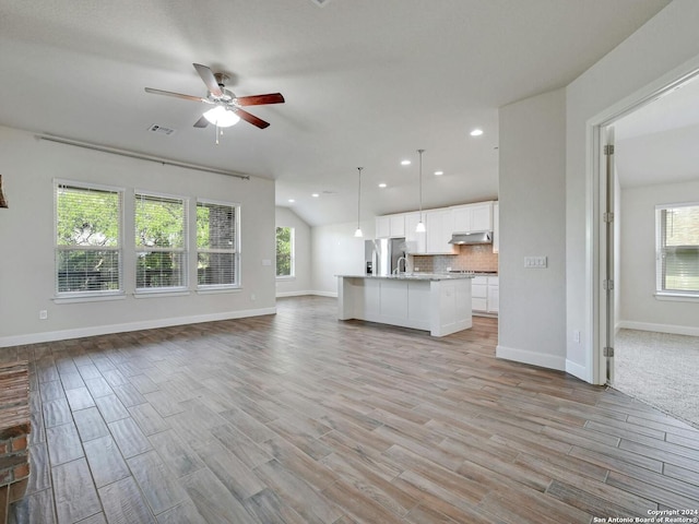 unfurnished living room featuring ceiling fan and light hardwood / wood-style floors