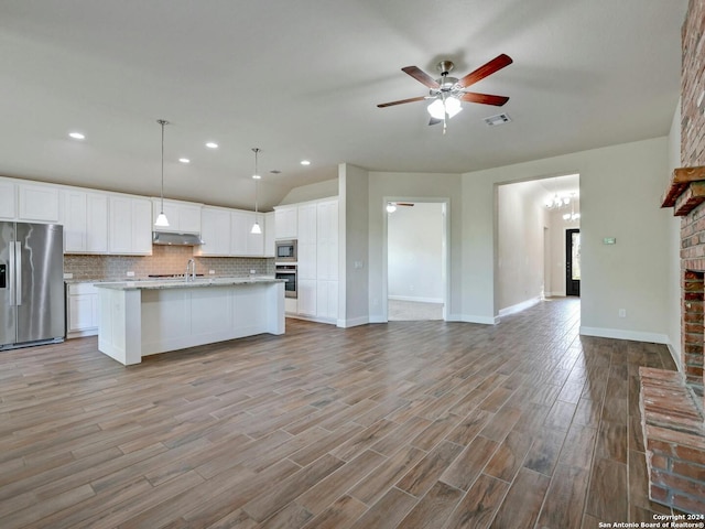 kitchen with a kitchen island with sink, white cabinets, hanging light fixtures, light hardwood / wood-style flooring, and stainless steel appliances