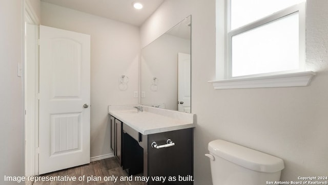 bathroom featuring wood-type flooring, vanity, and toilet