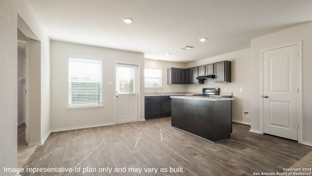 kitchen featuring stainless steel stove, light wood-type flooring, and a center island