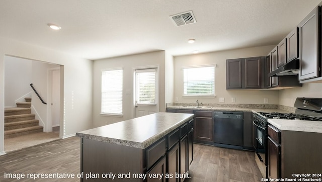 kitchen featuring a healthy amount of sunlight, dishwasher, a kitchen island, and gas stove