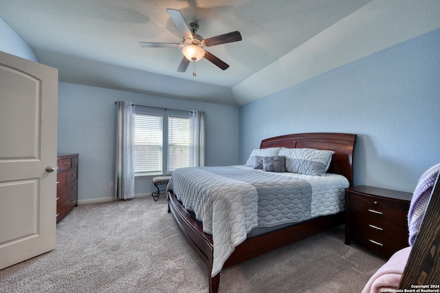 carpeted bedroom featuring ceiling fan, a textured ceiling, and lofted ceiling