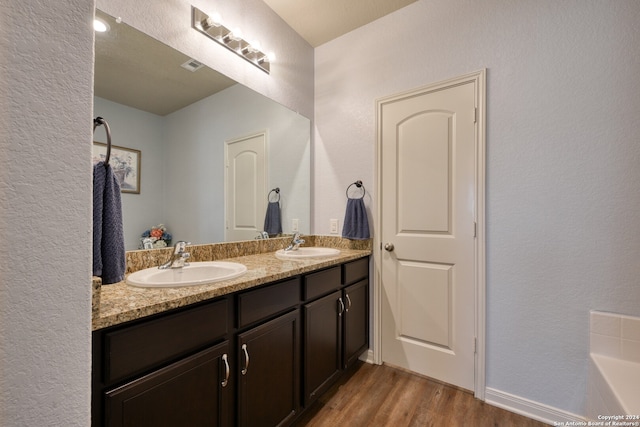 bathroom with vanity, a bathtub, and hardwood / wood-style flooring