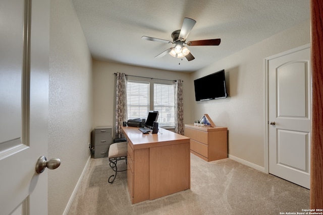 home office featuring ceiling fan, a textured ceiling, and light carpet