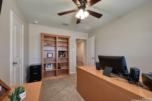 office space with a textured ceiling, light carpet, and ceiling fan