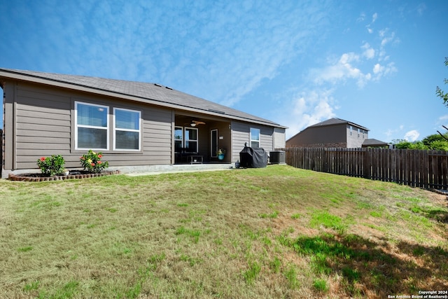 back of house with cooling unit, a lawn, and a patio