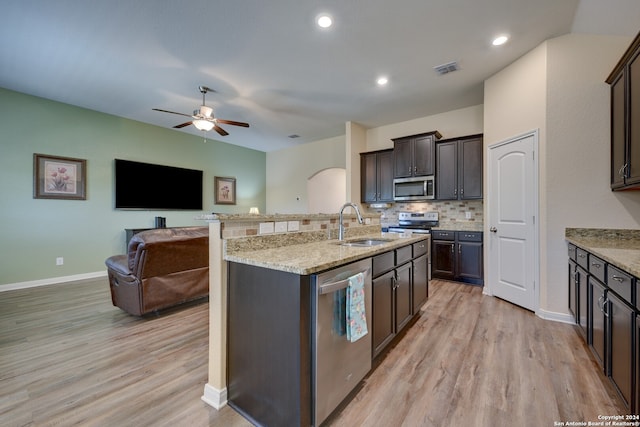 kitchen featuring ceiling fan, sink, dark brown cabinets, stainless steel appliances, and light wood-type flooring