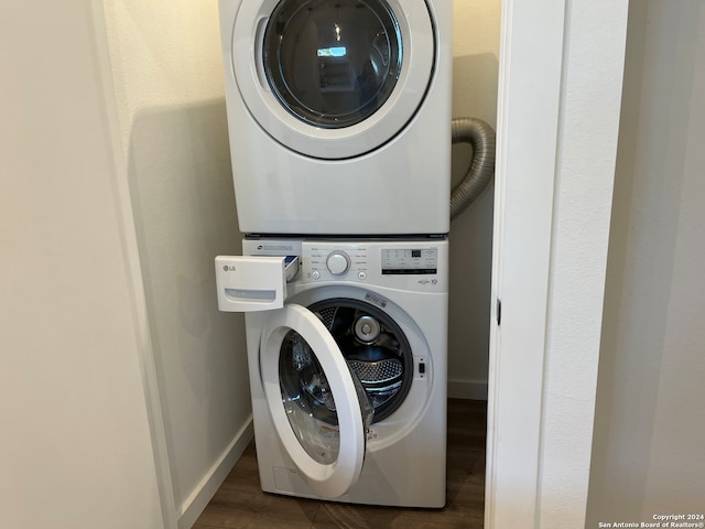 clothes washing area with stacked washer and clothes dryer and dark hardwood / wood-style floors