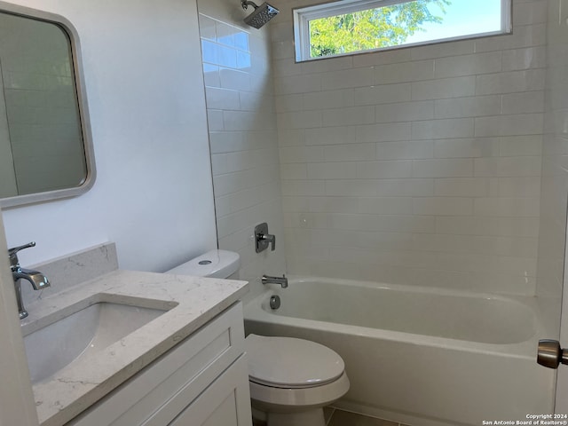 full bathroom featuring tiled shower / bath combo, vanity, and toilet