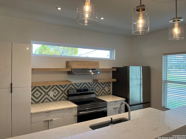 kitchen with a wealth of natural light, tasteful backsplash, electric range, and white cabinetry