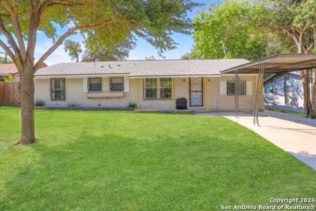 ranch-style home with a front yard and a carport