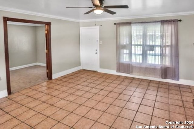 tiled empty room with ornamental molding and ceiling fan