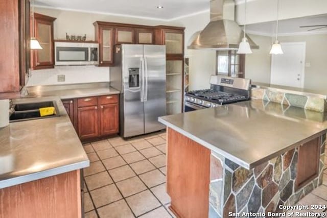 kitchen with pendant lighting, a breakfast bar area, wall chimney exhaust hood, appliances with stainless steel finishes, and light tile patterned floors