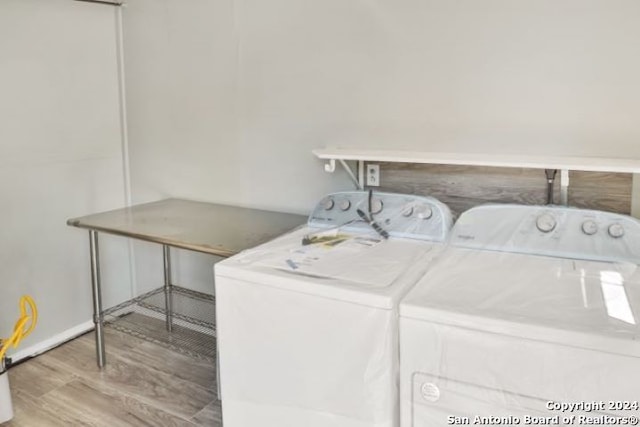 laundry room featuring hardwood / wood-style floors and washing machine and clothes dryer