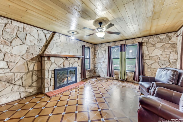 unfurnished living room featuring a fireplace, ceiling fan, and wood ceiling