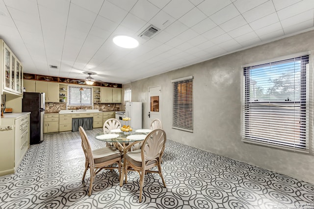 dining space featuring ceiling fan and sink