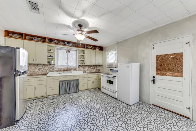 kitchen with cream cabinets, sink, ceiling fan, decorative backsplash, and appliances with stainless steel finishes