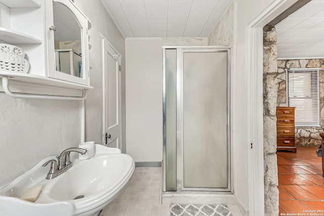 bathroom with sink, an enclosed shower, and tile patterned flooring