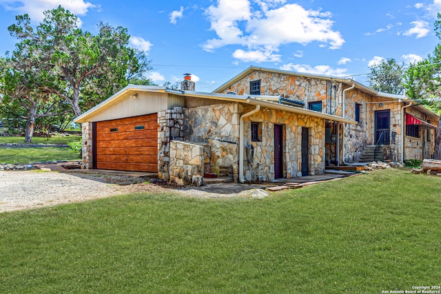 view of front of property with a garage and a front lawn