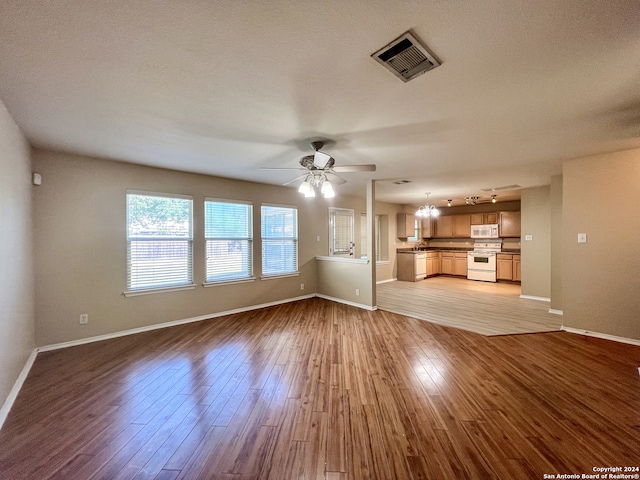 unfurnished living room featuring light hardwood / wood-style floors, ceiling fan, and a textured ceiling