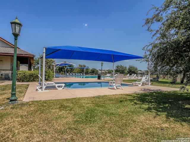 view of swimming pool featuring a lawn and a patio