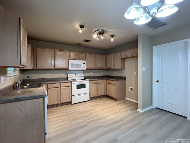 kitchen with pendant lighting, sink, white appliances, a chandelier, and light wood-type flooring