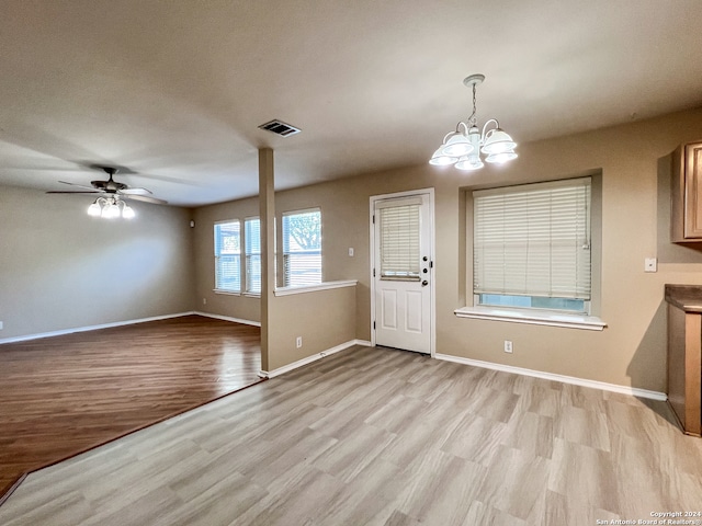 entrance foyer with ceiling fan with notable chandelier and light hardwood / wood-style flooring