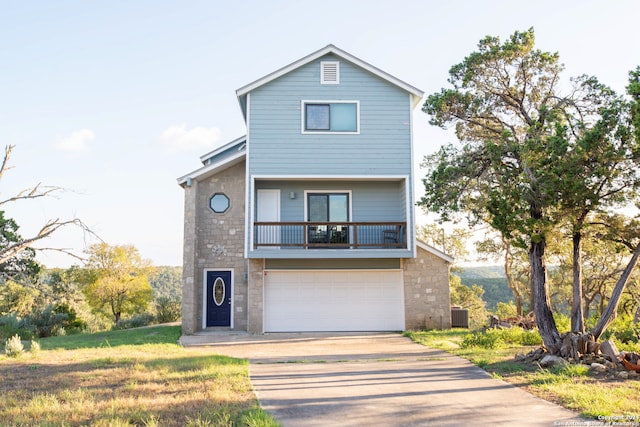 view of property with a balcony, central AC, and a garage