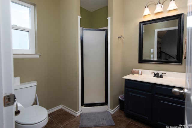 bathroom featuring tile patterned flooring, a shower with door, toilet, and vanity