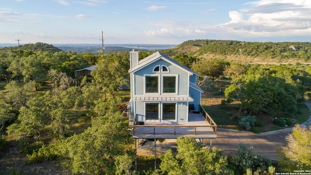 461 Naked Indian, New Braunfels, TX 78132 - rear view of house with a chimney, a deck, and a forest view