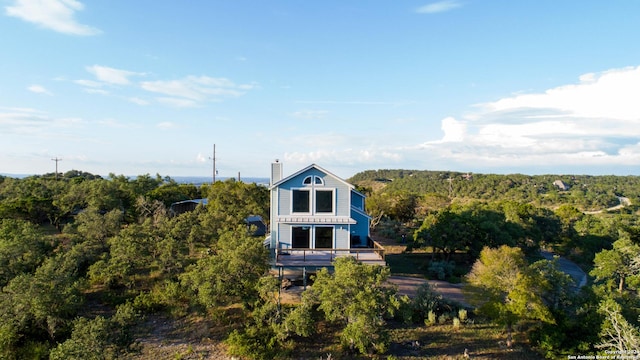 461 Naked Indian, New Braunfels, TX 78132 - back of property featuring a chimney and a wooded view
