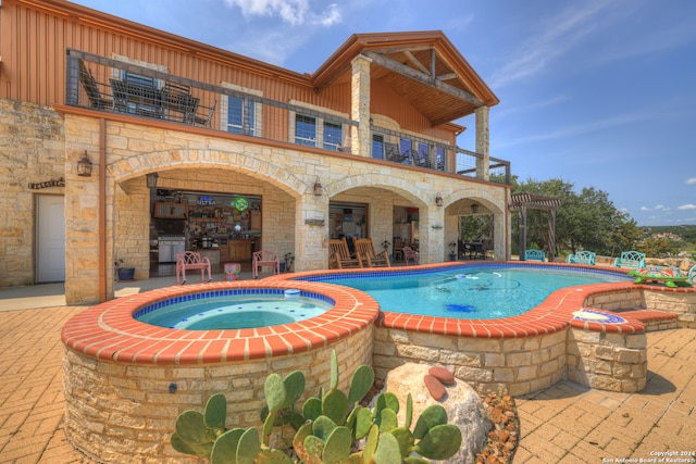 view of pool featuring a patio and an in ground hot tub