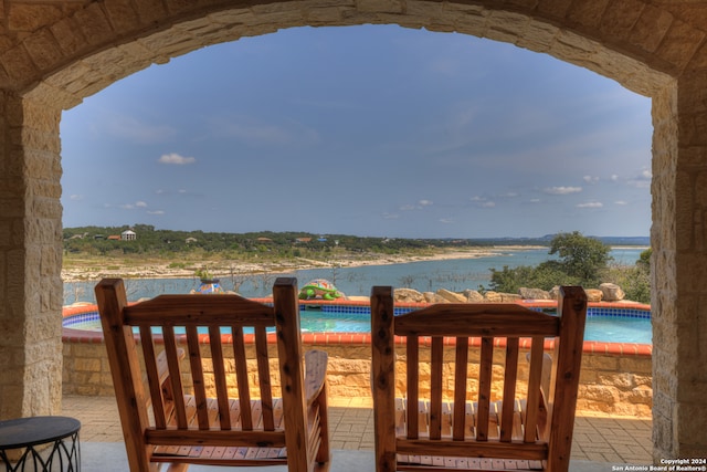 view of patio / terrace with a swimming pool and a water view