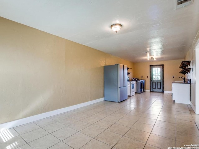 tiled spare room featuring washer / clothes dryer and sink