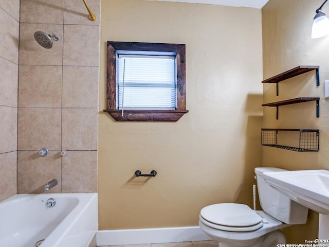 bathroom with toilet, tile patterned floors, and tiled shower / bath